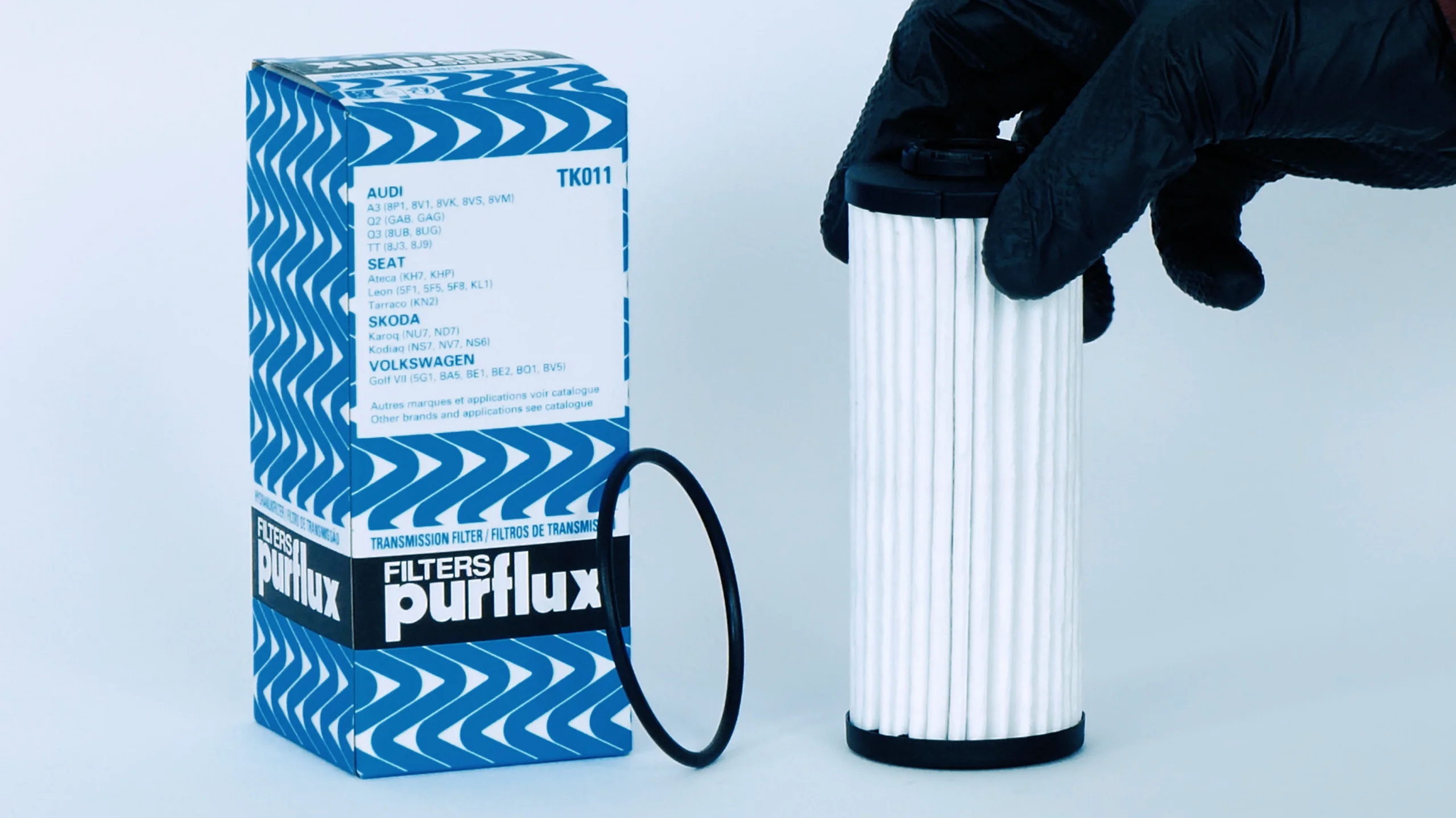 Gros plan produit : filtre Purflux, joint et boîte sur fond bleu clair